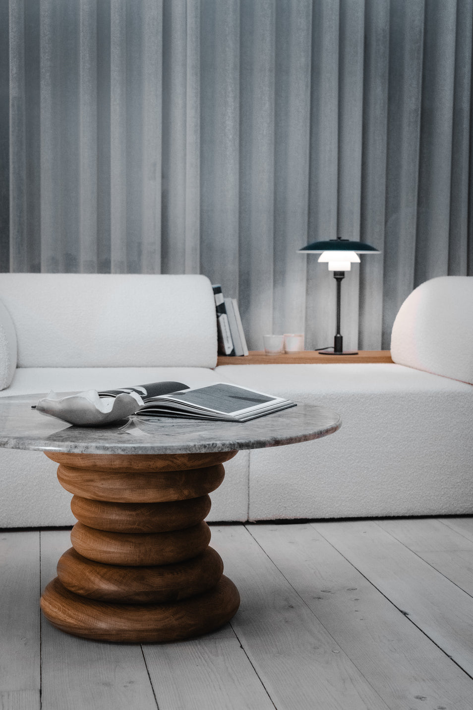 Spine Coffee Table pairs an architectural base of stacked solid-wood rings with a polished stone top, Wooden table with marble top