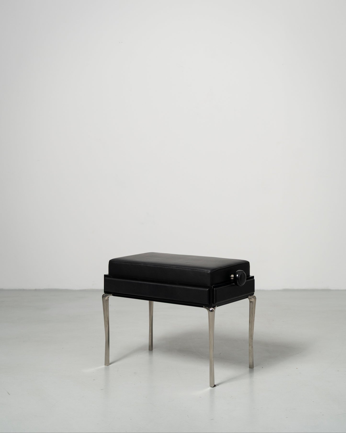 Piano Bench scandinavian design black leather seat with height adjustment leather panels on the side and chrome metal legs 
