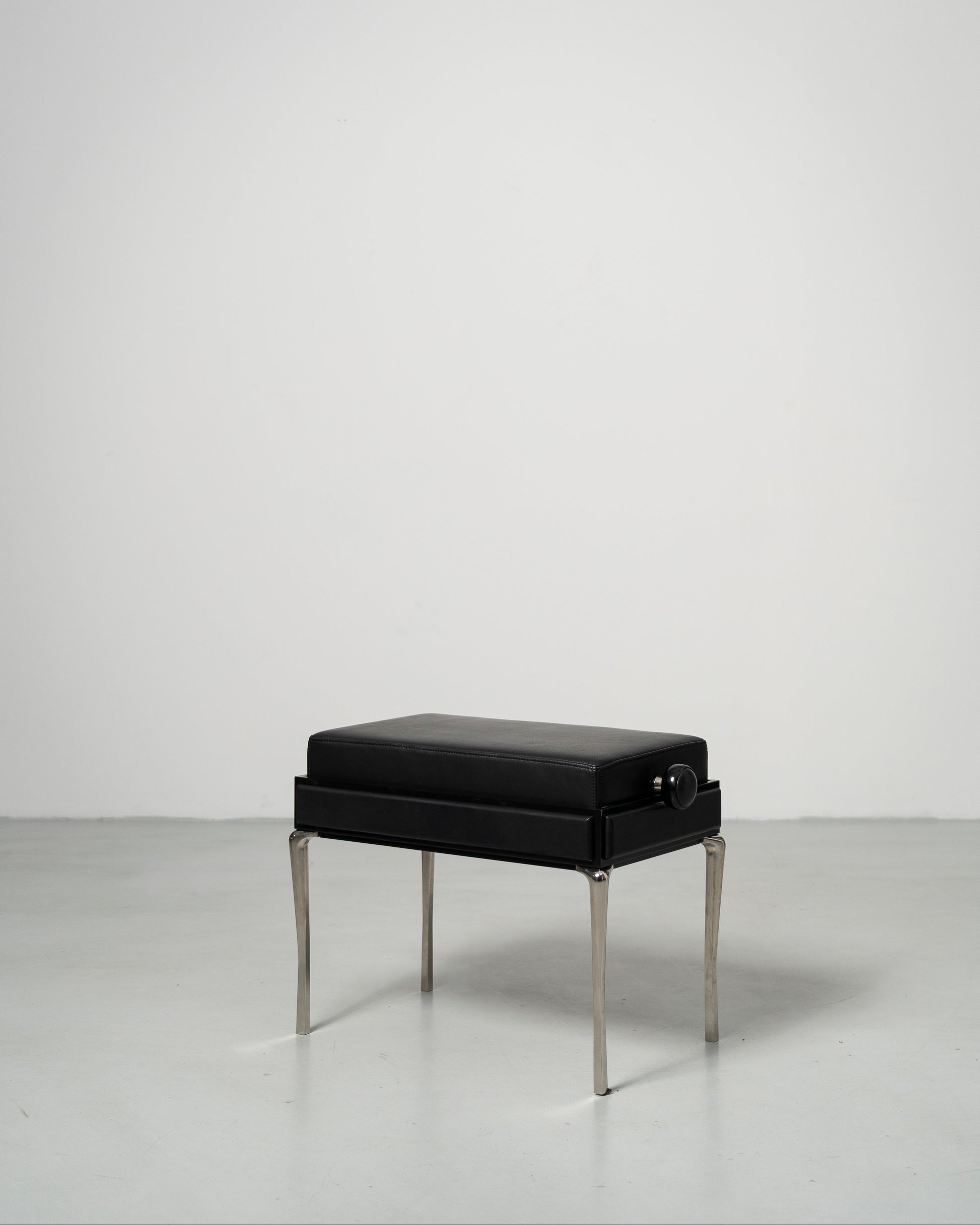Piano Bench scandinavian design black leather seat with height adjustment leather panels on the side and chrome metal legs 
