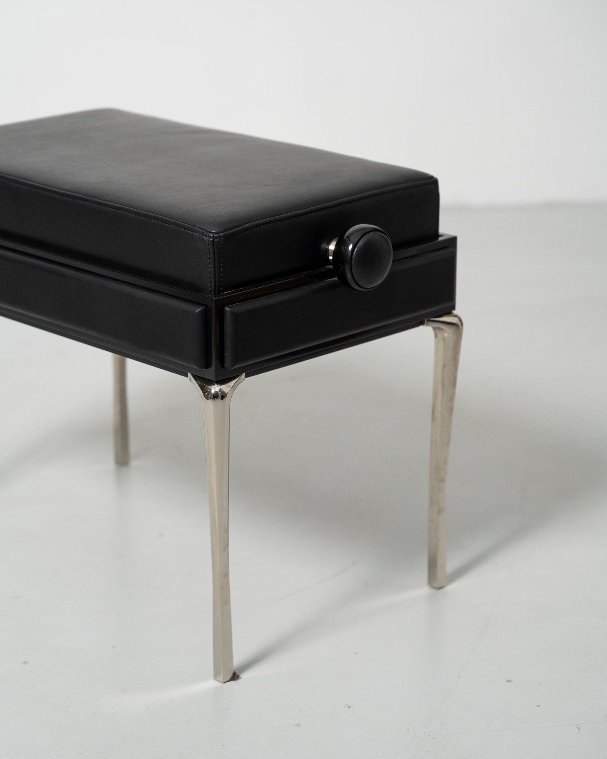 Piano Bench scandinavian design black leather seat with height adjustment leather panels on the side and chrome metal legs 
