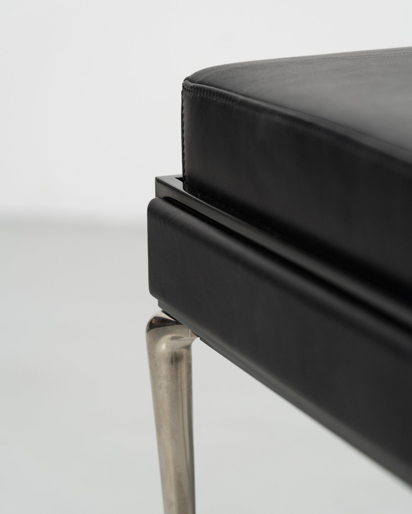 Piano Bench scandinavian design black leather seat with height adjustment leather panels on the side and chrome metal legs 
