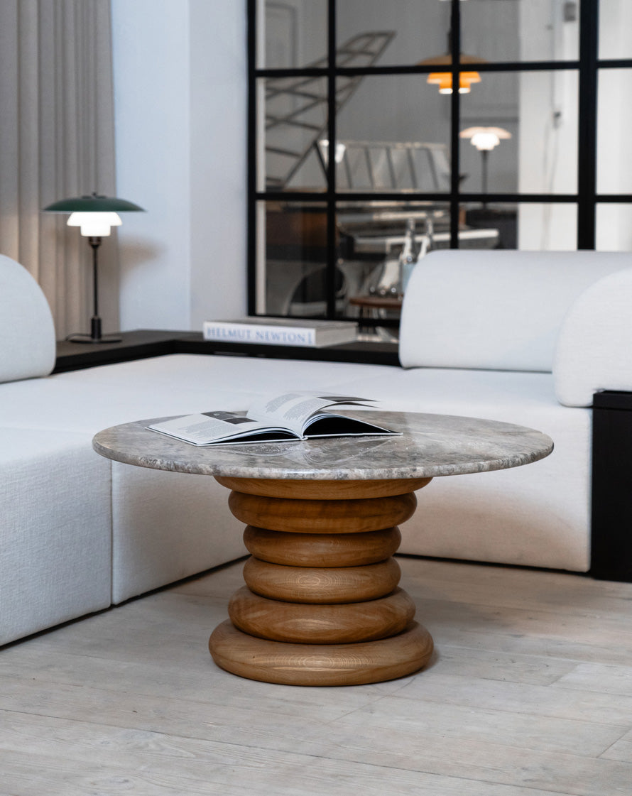 Spine Coffee Table pairs an architectural base of stacked solid-wood rings with a polished stone top, Wooden table with marble top 
